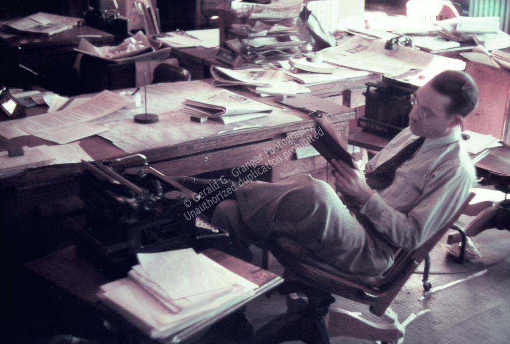 Photo of a man with his feet up on his desk
