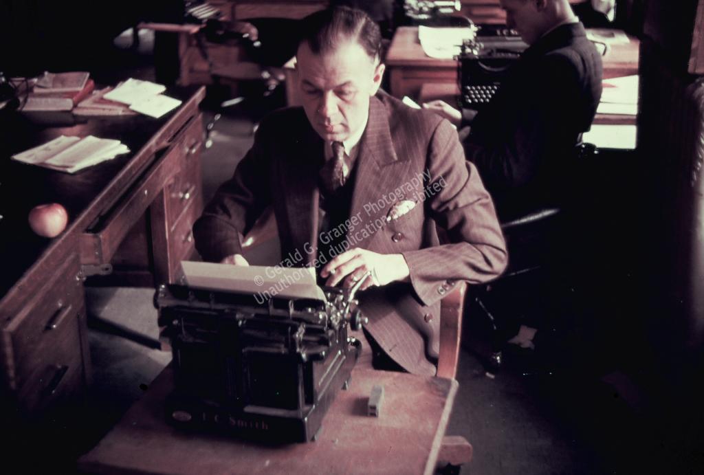 Photo of a man at a typewritter